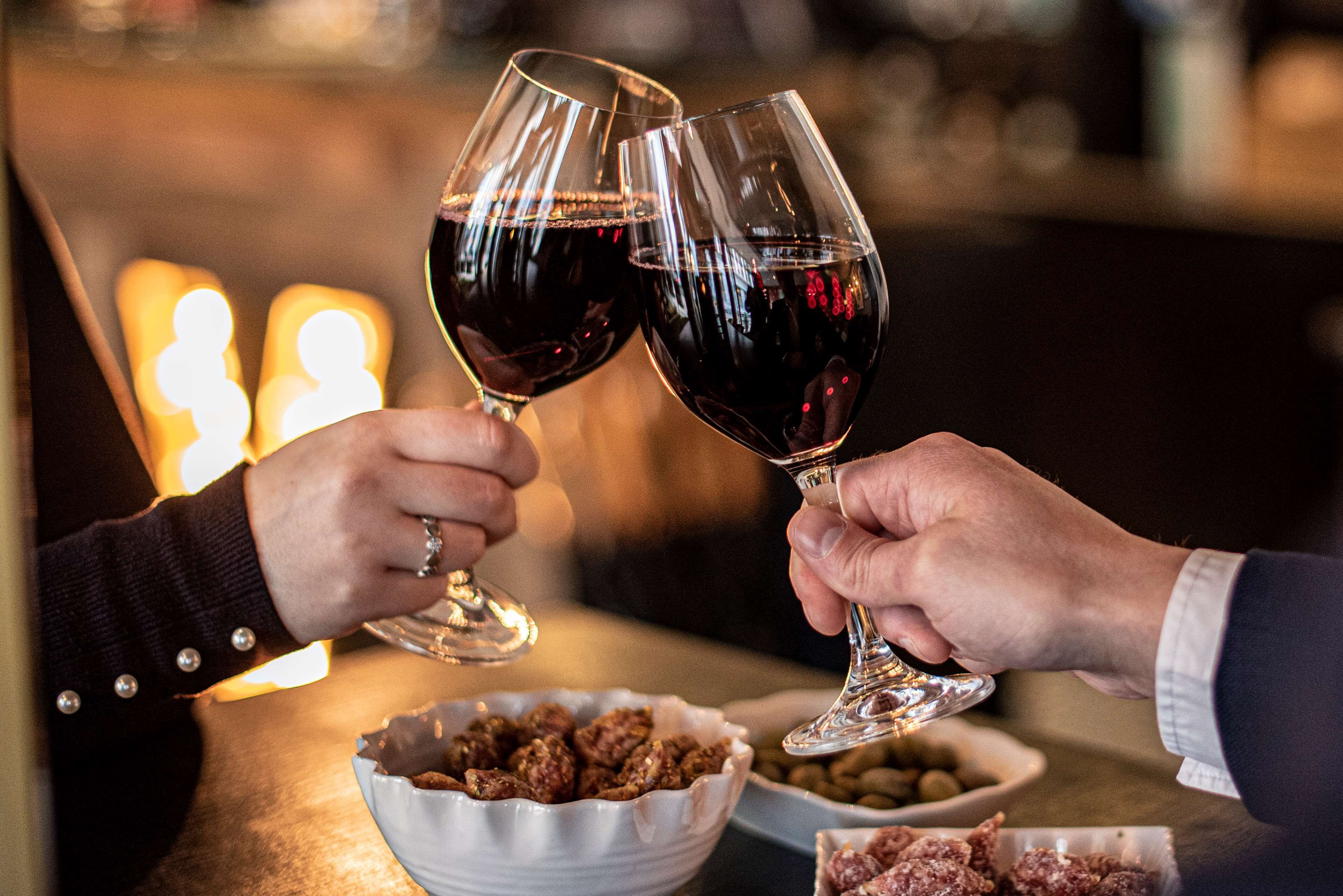 Due persone che brindano con bicchieri di vino.