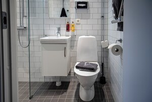 Un baño moderno con inodoro, lavabo y ducha.