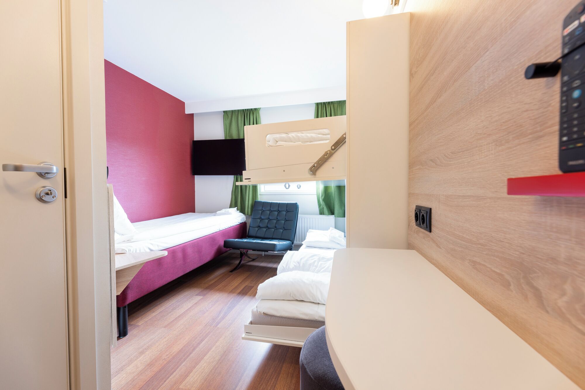 Habitación pequeña con una litera, un escritorio y una silla.