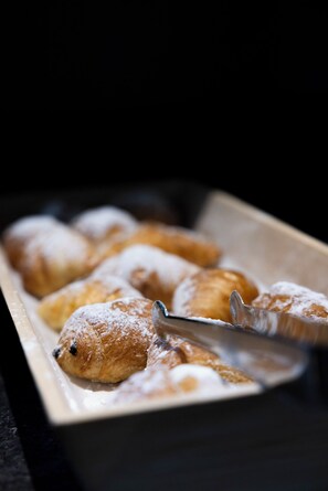 A tray of pastries dusted with powdered sugar.