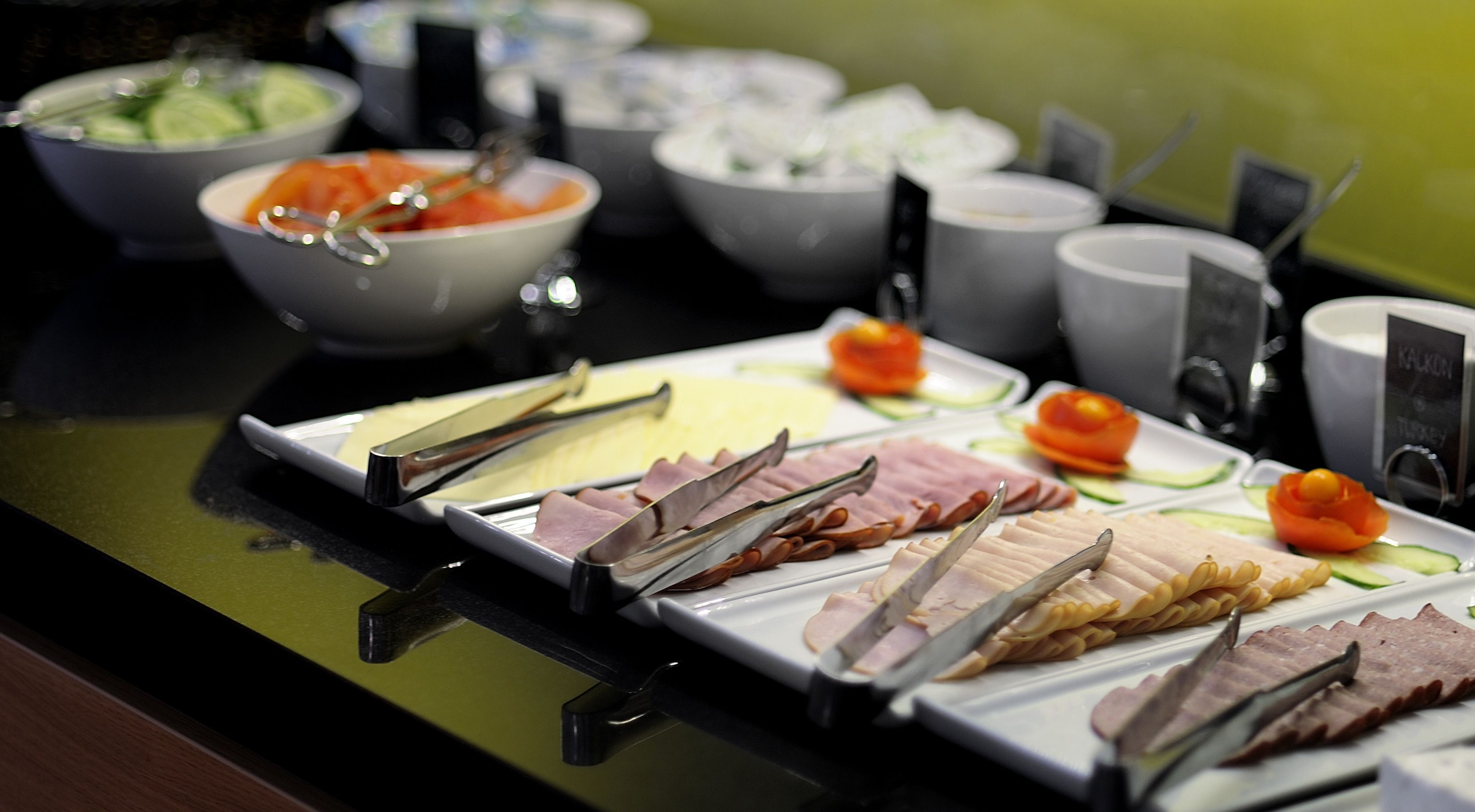 Un bufé con diversos alimentos, incluyendo carnes, ensaladas y frutas.