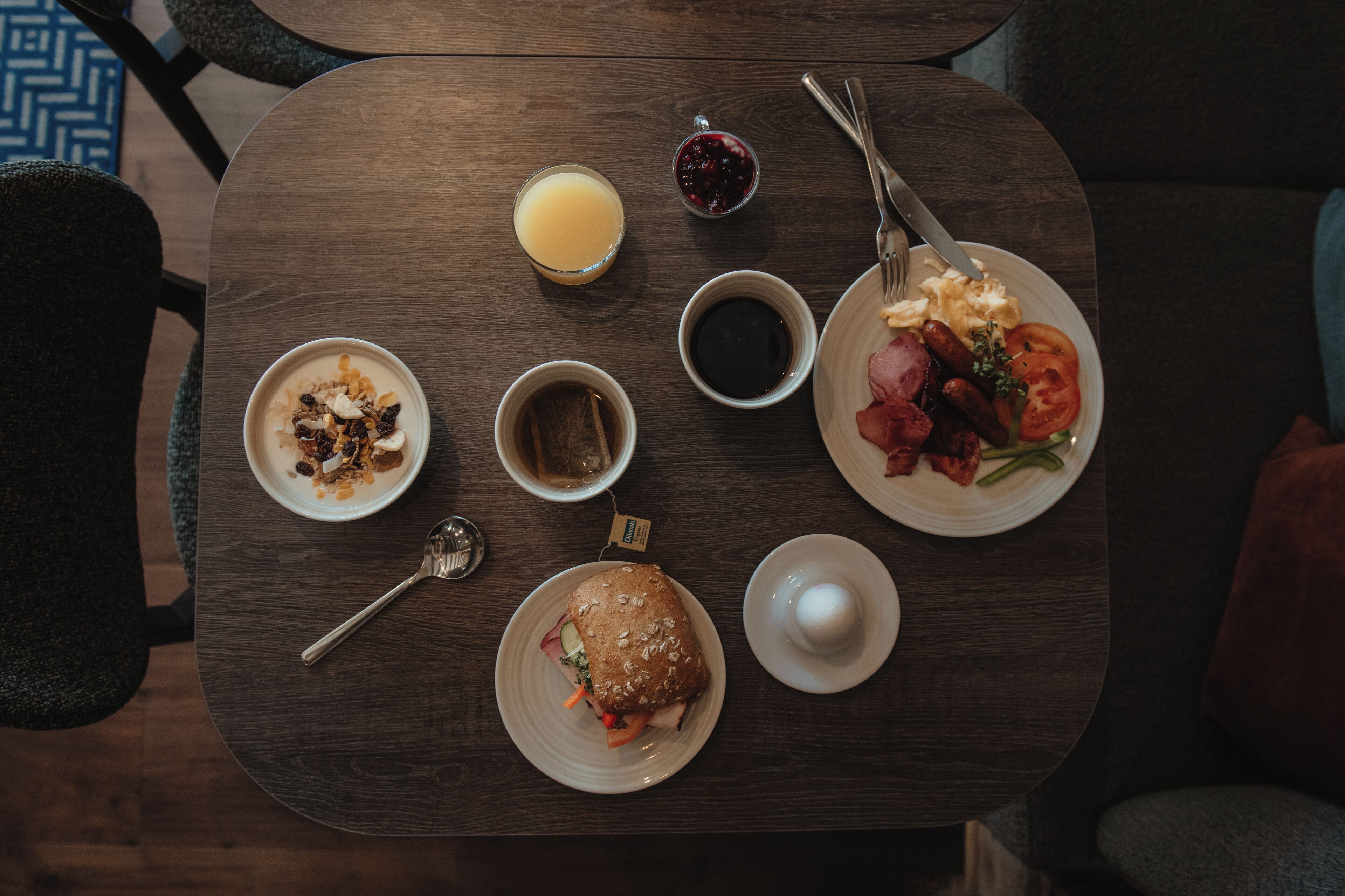 A breakfast table with various food items and drinks.