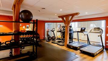 A gym with treadmills, elliptical machines, and weightlifting equipment.
