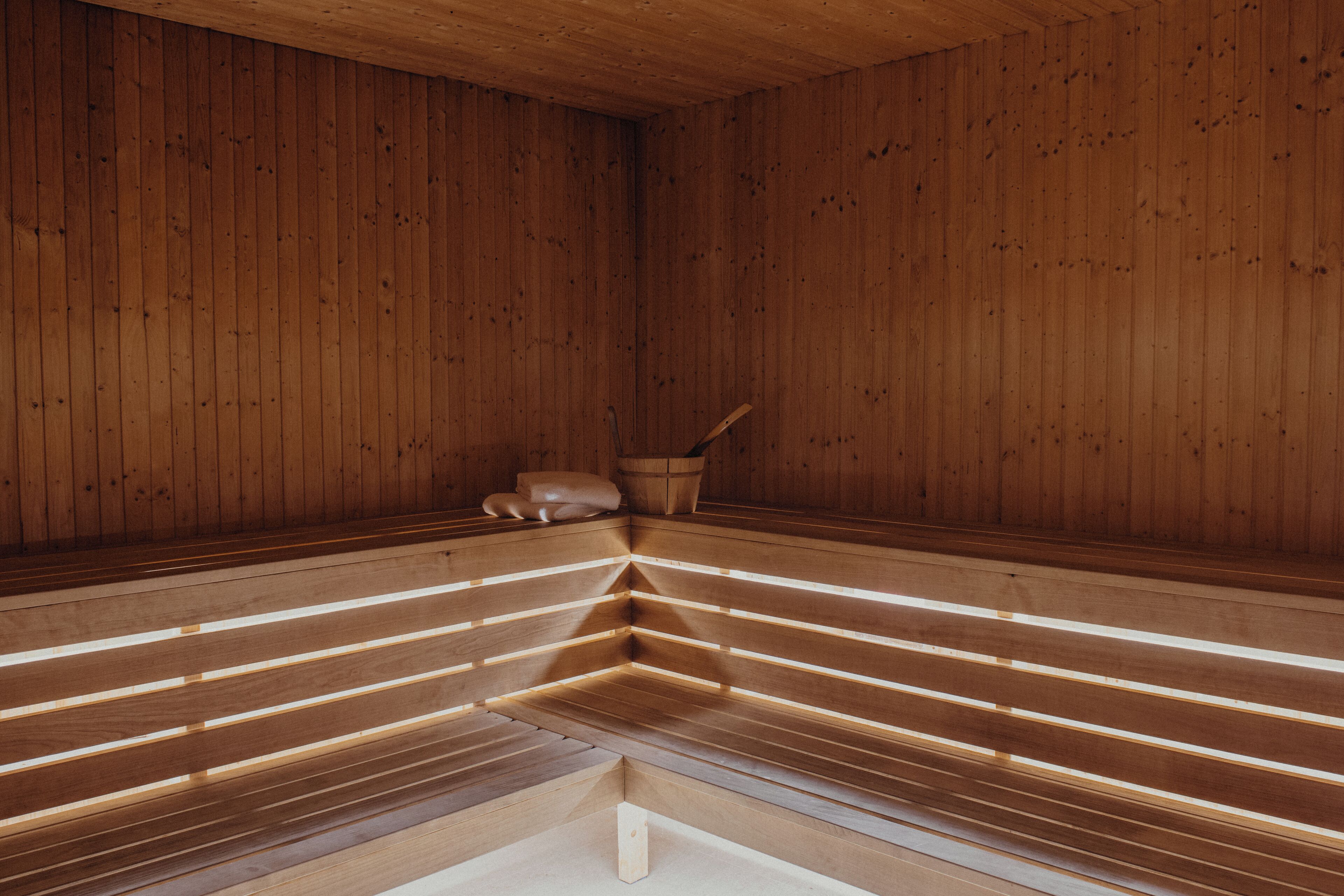 Una sauna con bancos de madera y un banco central.