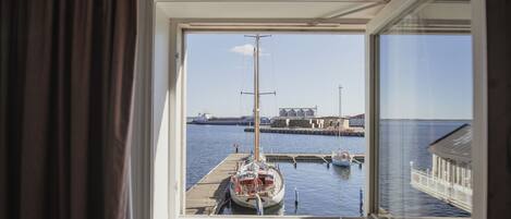 A view from a window of a docked sailboat at a marina.