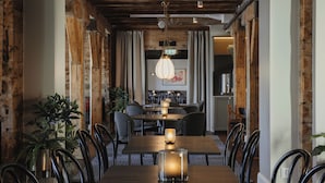 Un comedor con una mesa de madera, sillas y una lámpara colgante.