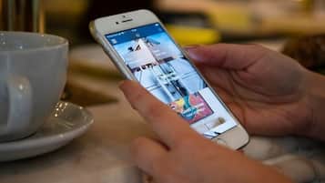 A person holding a smartphone with a shopping app open, displaying a product.