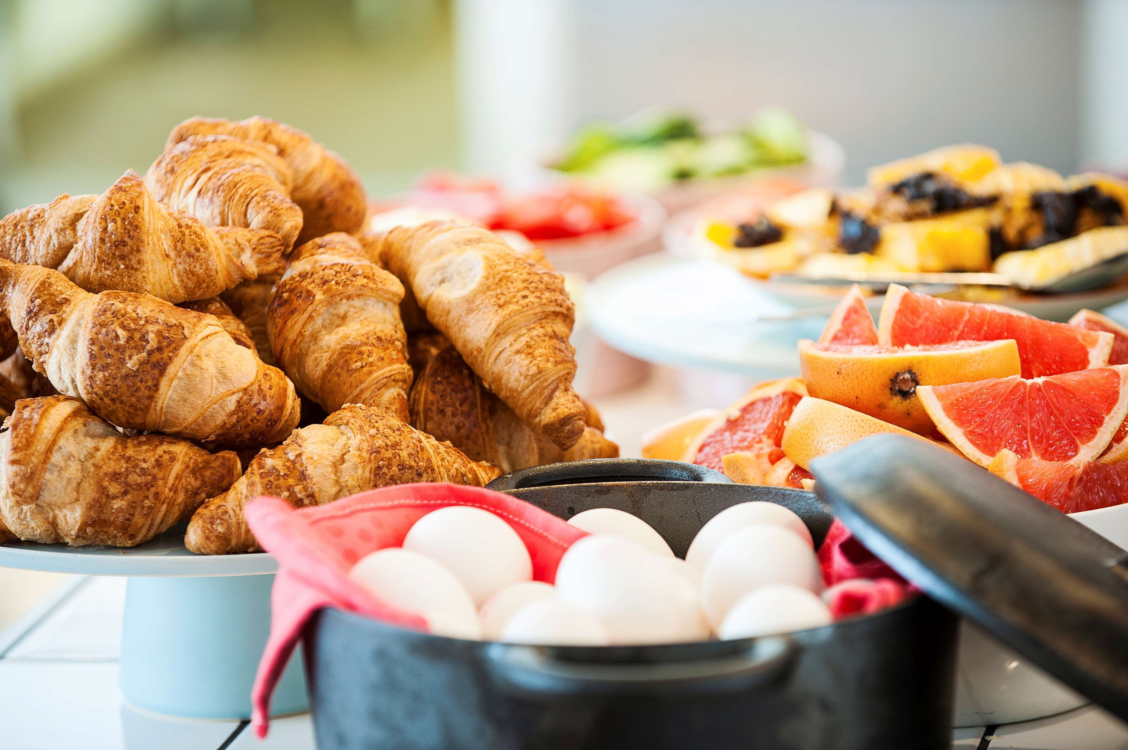 Un buffet de petit-déjeuner avec des croissants, des pamplemousses et des œufs.