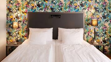 A double bed with white linens, a dark headboard, and two bedside lamps with patterned shades.