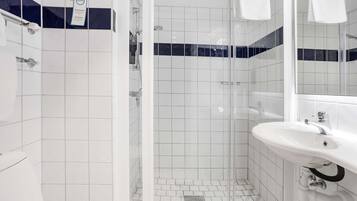 A bathroom with a shower, a sink, and a mirror.