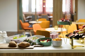 A buffet table with various food items and a decorative centerpiece. - ProfilHotels Garden (Malmö)