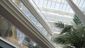 Een hoge plafond met een glazen atrium, waardoor natuurlijk licht binnenvalt.