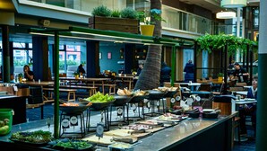 Een buffetgedeelte met diverse food stations, een centraal bedieningspunt en zitplaatsen in een ruime, overdekte ruimte.