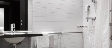 A modern bathroom with a white sink, mirror, and shower.