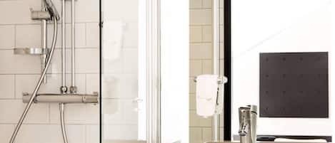 Un baño moderno con cabina de ducha de vidrio, un lavabo con grifo y dispensador de toallas.