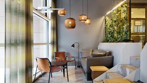 Ein modernes Wohnzimmer mit Sofa, Sesseln, Couchtisch und Wendeltreppe.