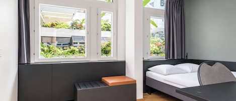 Una habitación moderna con una cama, un banco y una mesa.