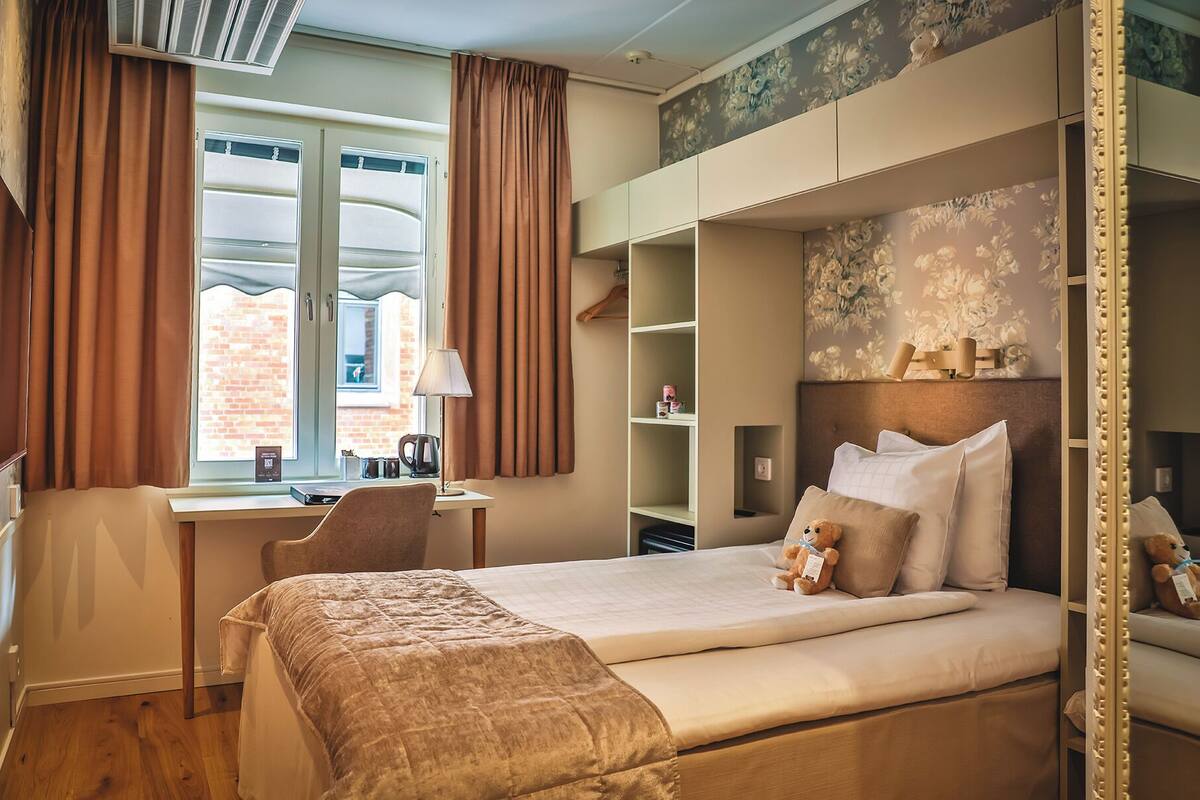 Ein Hotelzimmer mit einem Bett, einem Schreibtisch und einem Kleiderschrank.