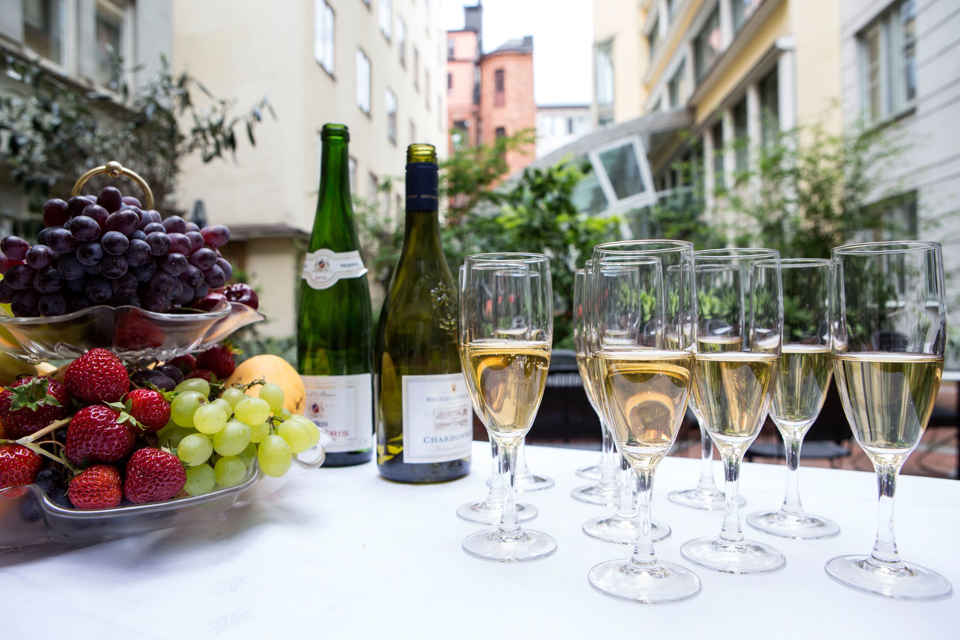 Ett bord med en fruktskål, vinflaskor och glas.