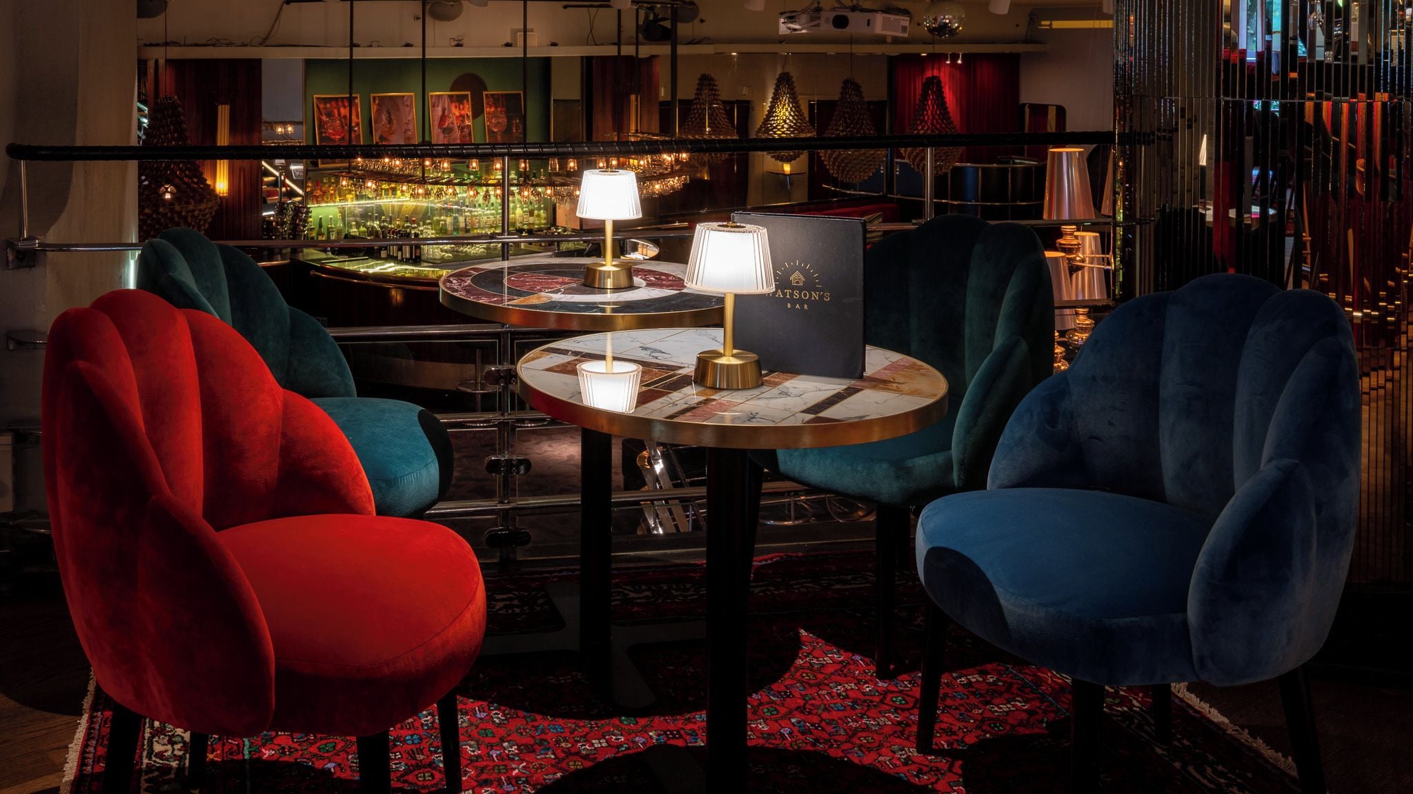 A bar area with round tables, chairs, and a bar counter.