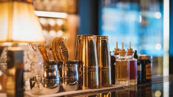 A bar area with various glassware and bottles, a lamp, and a reflective surface.