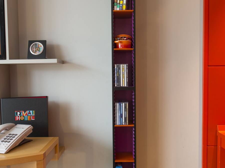 A bookshelf with various items including books, DVDs, and a framed picture.