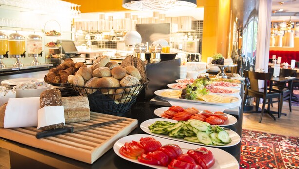 A buffet with various food items including bread, vegetables, and meats. - Hotel Rival (Stockholm)