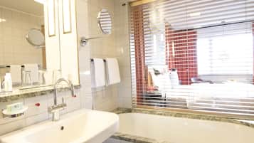 Een badkamer met een wastafel, spiegel en bad.