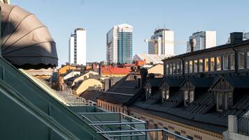 A cityscape with a mix of modern and traditional architecture, including a prominent building with a crane on top, suggesting ongoing construction.