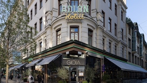 Entrada de un hotel con un cartel que dice 'GIOIA Hotel' y 'ADLON Hotel'.