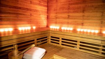 A sauna with wooden benches and benches, a wooden bucket, and a towel.