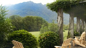 A patio with Adirondack chairs overlooking a mountainous landscape. - Hotel Bellinzona Sud Swiss Quality (Bellinzona)