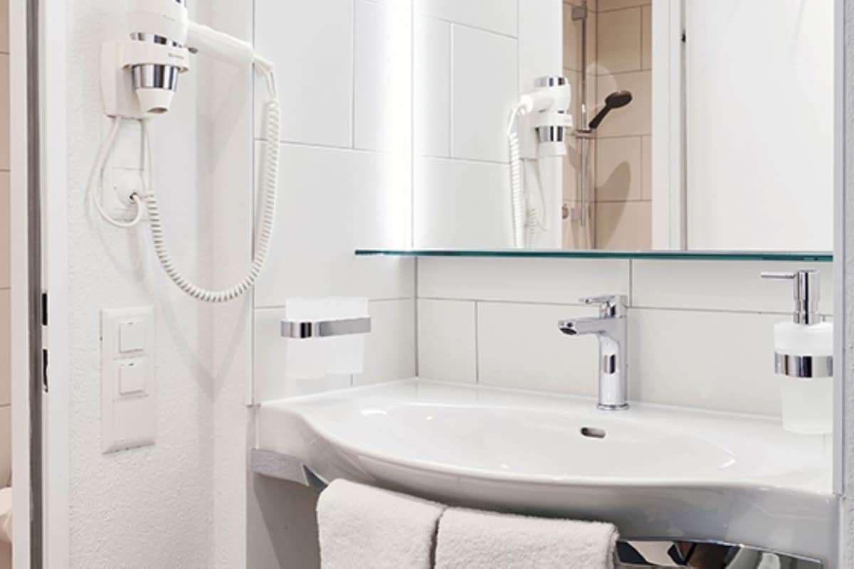 Badkamer | Een douche, een haardroger, handdoeken