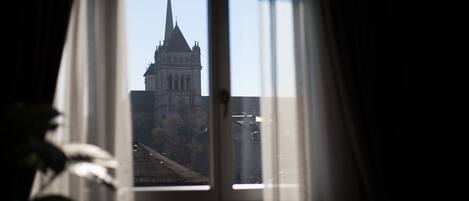 Vista a través de una ventana que muestra un edificio con una aguja alta.