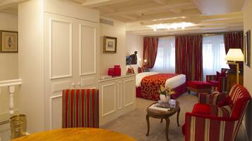 Une chambre d’hôtel avec un lit, un bureau, une chaise, une table et une lampe.