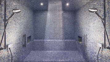 Een aparte badkuip en douche, een regendouche, designer toiletartikelen
