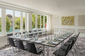 A conference room with a long table, chairs, and water bottles.