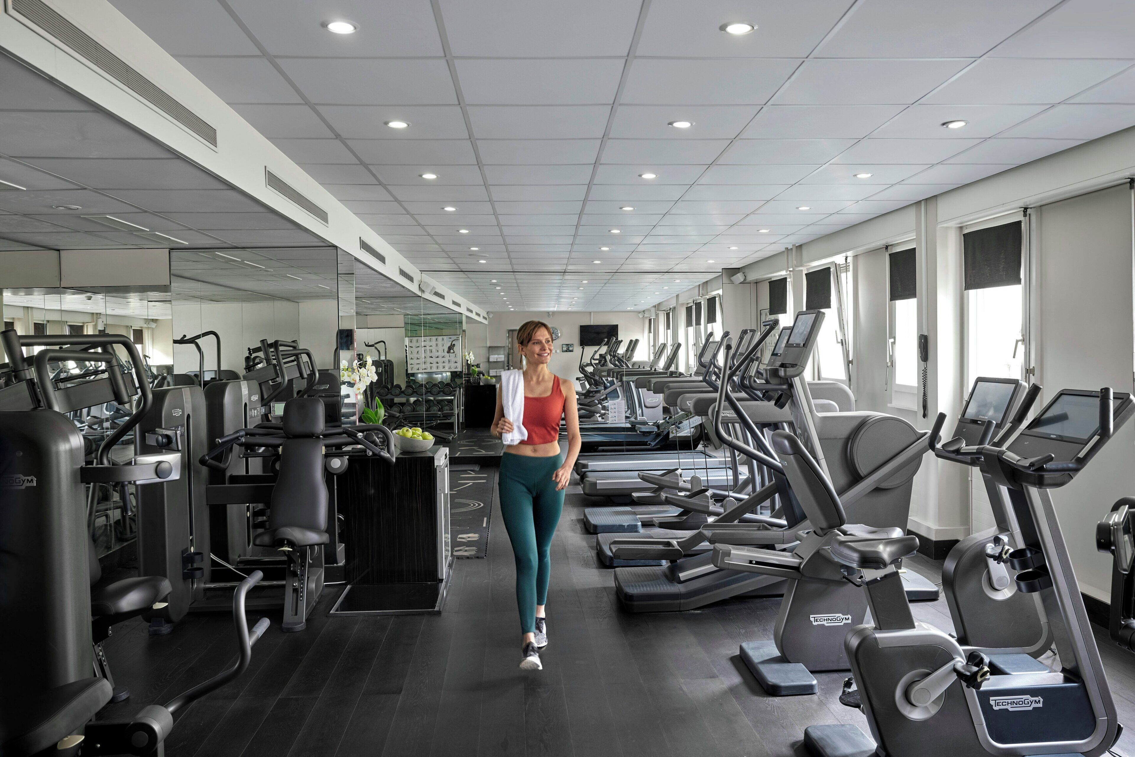 A gym with treadmills, elliptical machines, and weight equipment.