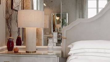 A bedroom with a bed, bedside table, lamp, and decorative items.