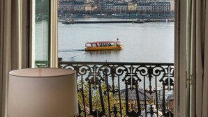 A balcony with a view of a river, a boat, and a distant mountain. - Hotel d'Angleterre Geneva (Geneva)