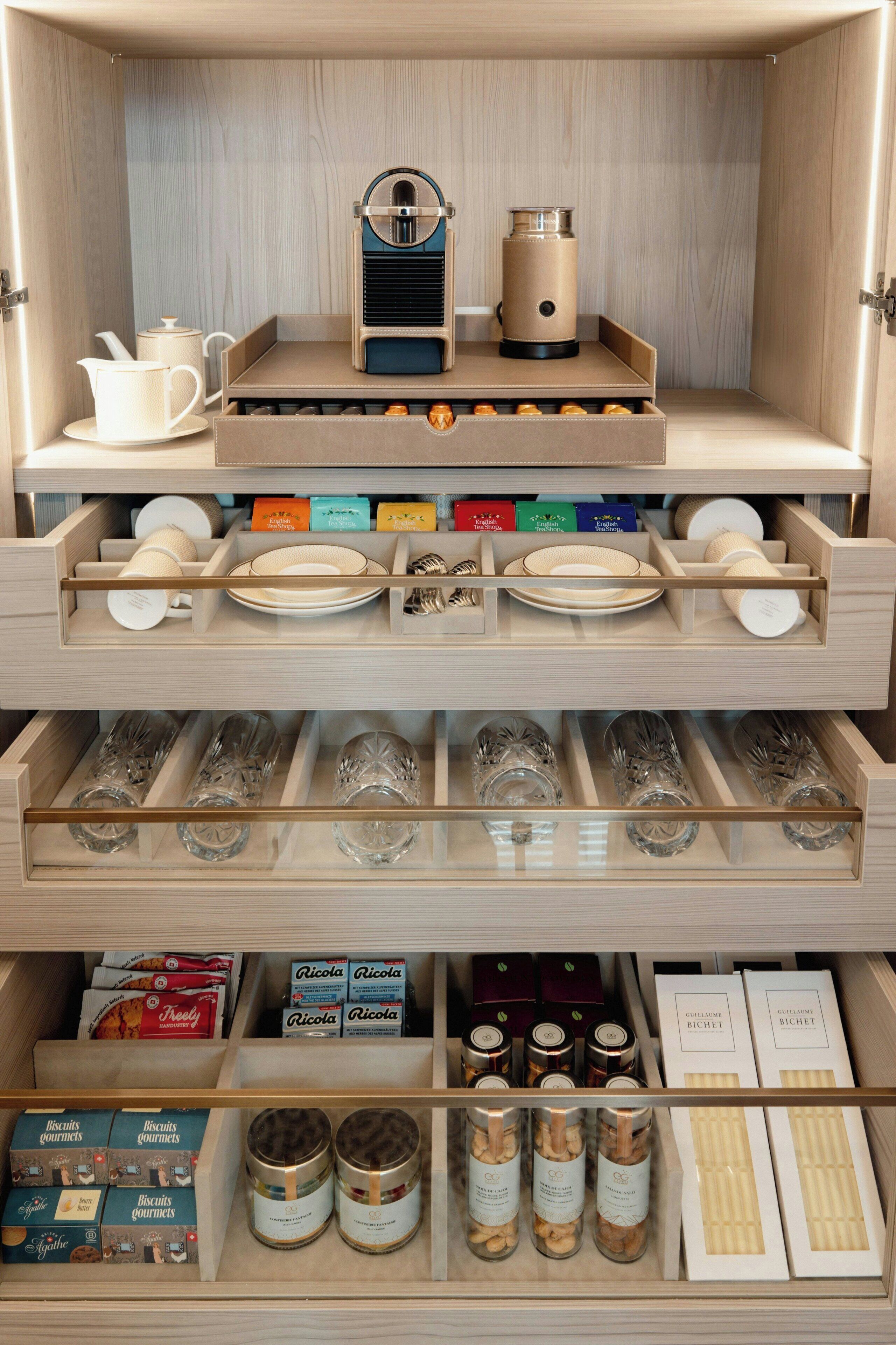 Eine Küche mit Kaffeemaschine, Wasserkocher sowie Stauraum für Gläser und Lebensmittel.