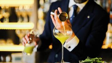 Un barman sirviendo una bebida en una copa de martini.