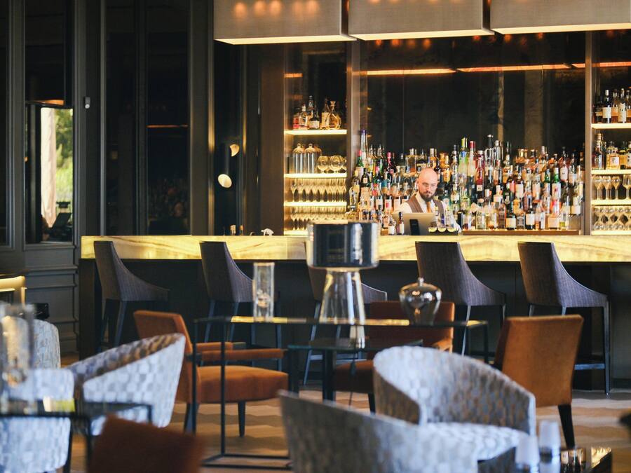 A bar area with multiple seating options and a well-stocked bar.