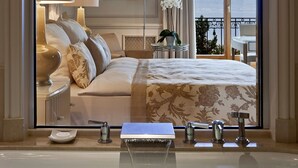 A hotel room with a large bed, a bathroom with a bathtub, and a view of the sea. - Beau-Rivage Palace (Lausanne)