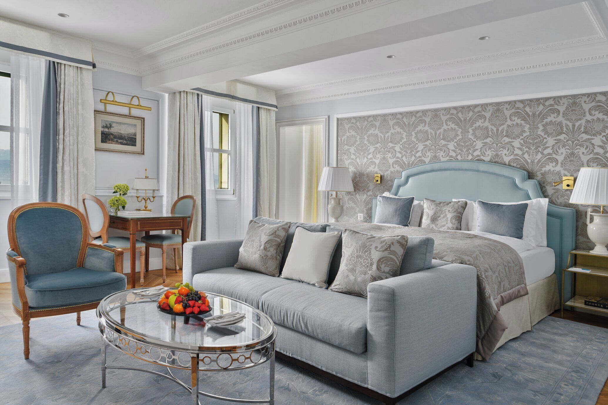 Una habitación de hotel moderna con cama, sofá, mesa de comedor y una mesita de centro.