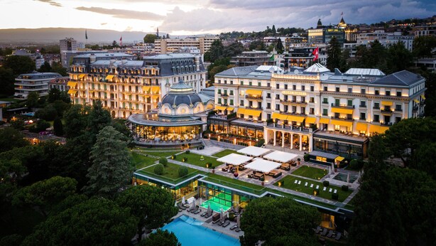 A hotel with a pool, outdoor seating, and a large building with multiple stories and balconies. - Beau-Rivage Palace (Lausanne)
