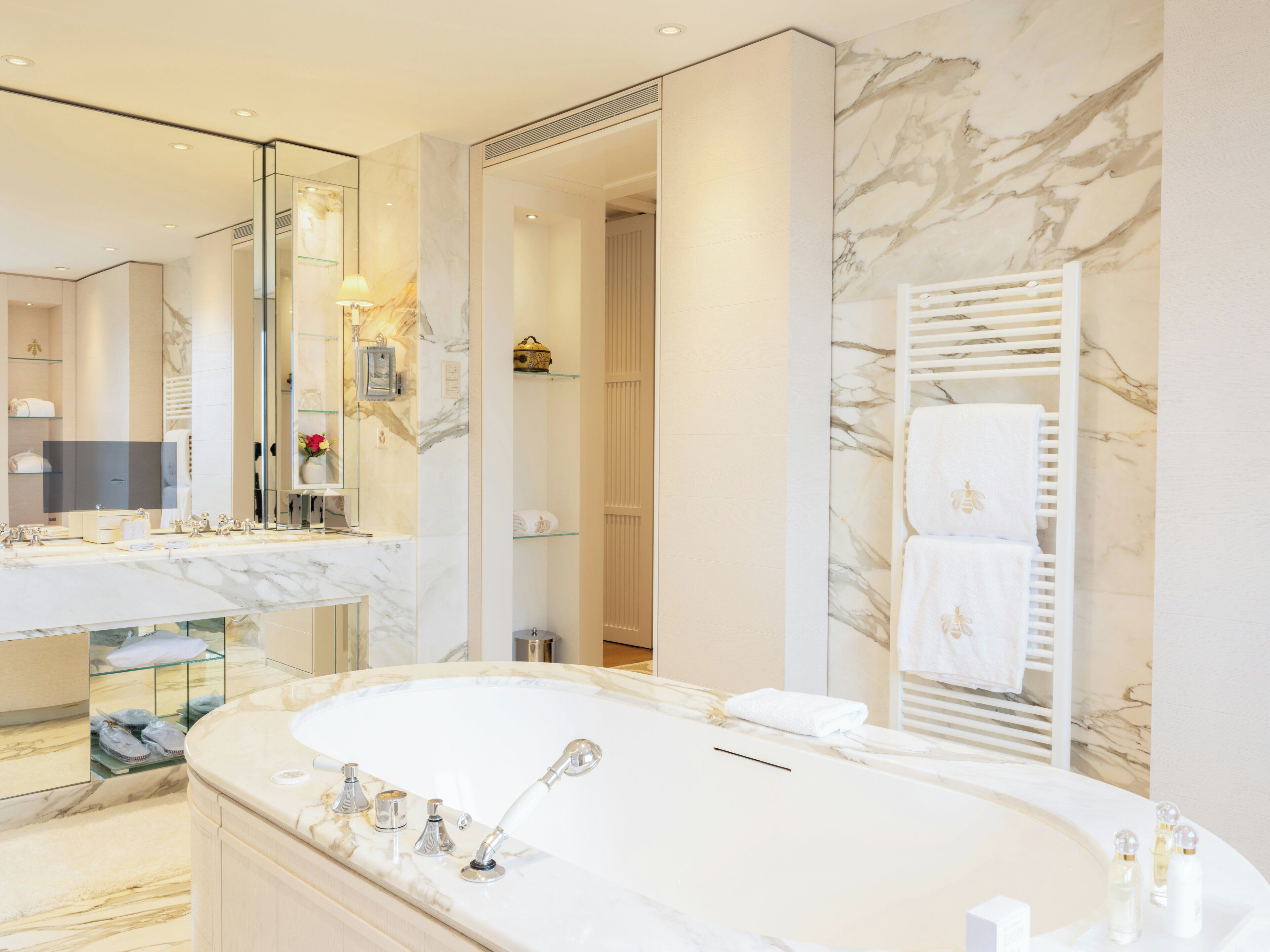 Une salle de bain moderne avec une grande baignoire, un meuble-lavabo avec un miroir et une cabine de douche en verre.