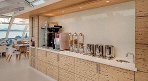 A modern bar area with a coffee machine, condiment dispensers, and a sink. - Agora Swiss Night by Fassbind (Lausanne)