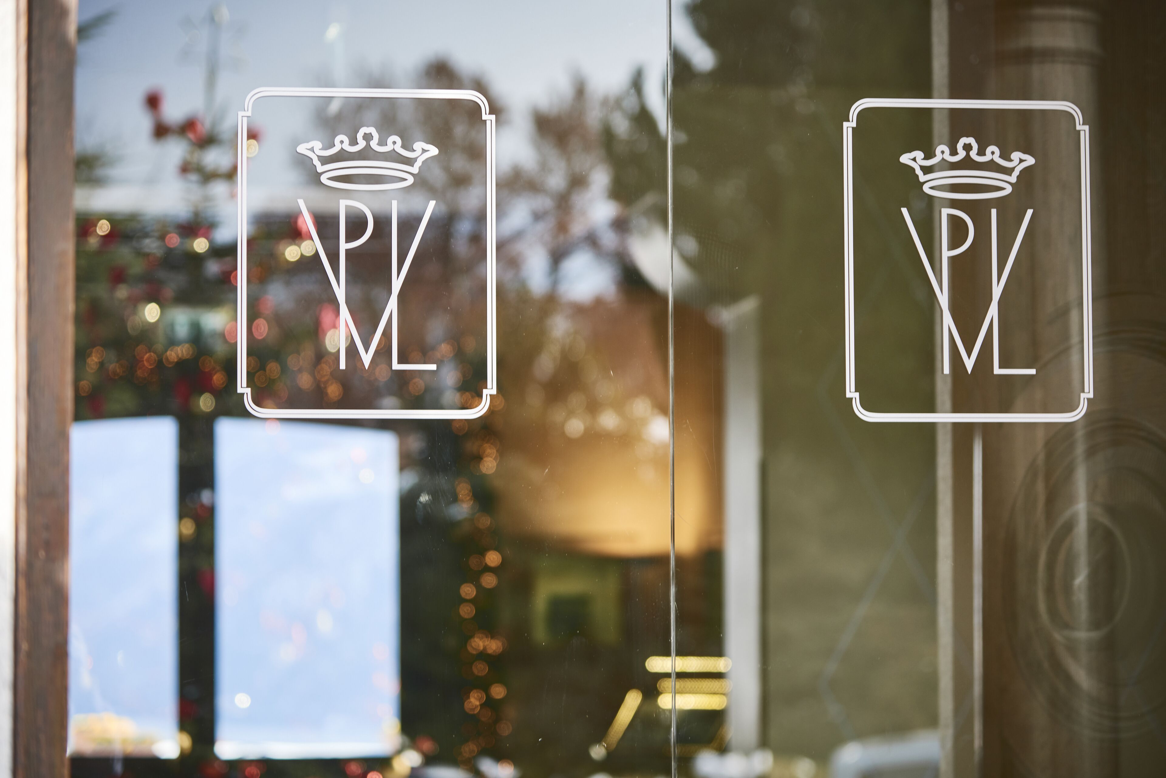 A window with a logo featuring a crown and the letters "PV" inside a rectangle.