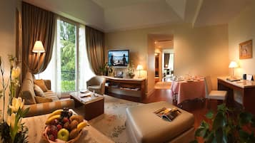 Une chambre d’hôtel équipée d’un canapé, d’une table à manger, d’une télévision et d’un petit coin cuisine.